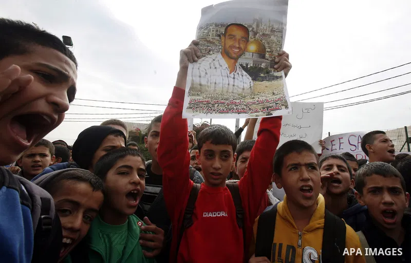 Relatives of Palestinians jailed in Israel demonstrate with placards of a detained prisoner, Tareq Issawi, who is on a hunger strike, as they protest for his release in Jerusalem, 27 November 2012. Photo by Mahfouz Abu T...