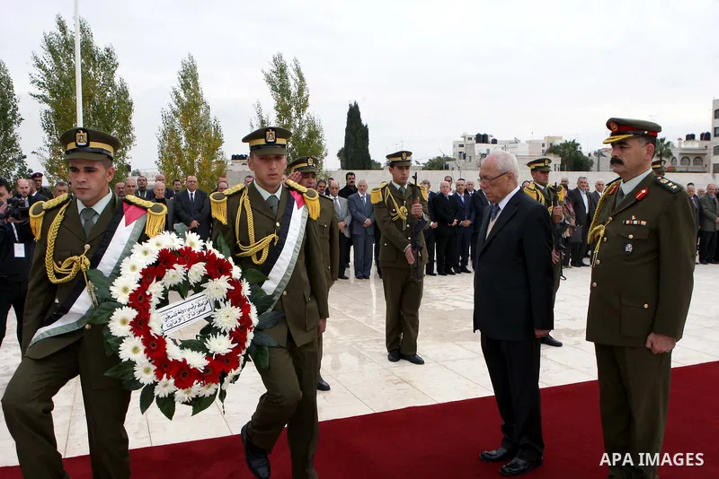 Palestinian presidency head Tayeb Abdelrahim (C-R) walks between lines of Palestinian honour guards standing to attention as he leaves the mausoleum of the late Palestinian leader Yasser Arafat, after a funeral ceremony...