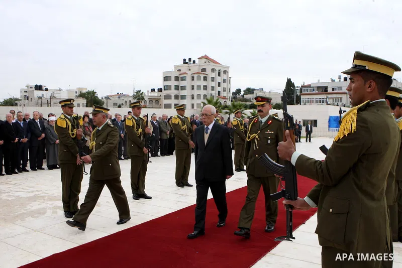 Palestinian presidency head Tayeb Abdelrahim (C-R) walks between lines of Palestinian honour guards standing to attention as he leaves the mausoleum of the late Palestinian leader Yasser Arafat, after a funeral ceremony...