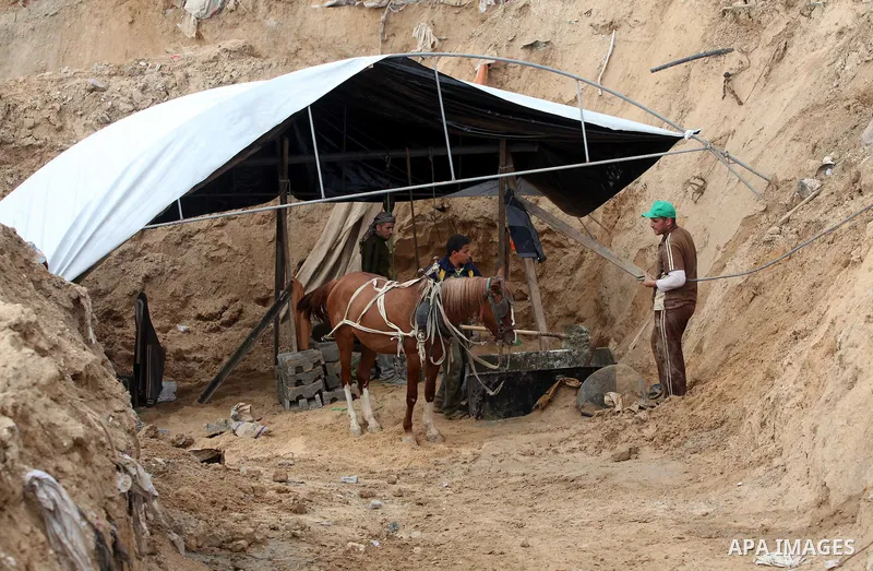 Palestinians work at the entrance of a smuggling tunnels dug beneath the Egyptian-Gaza border in Rafah, in the southern Gaza Strip November 27, 2012. Knee-deep in craters carved out by Israeli air strikes, Palestinians w...
