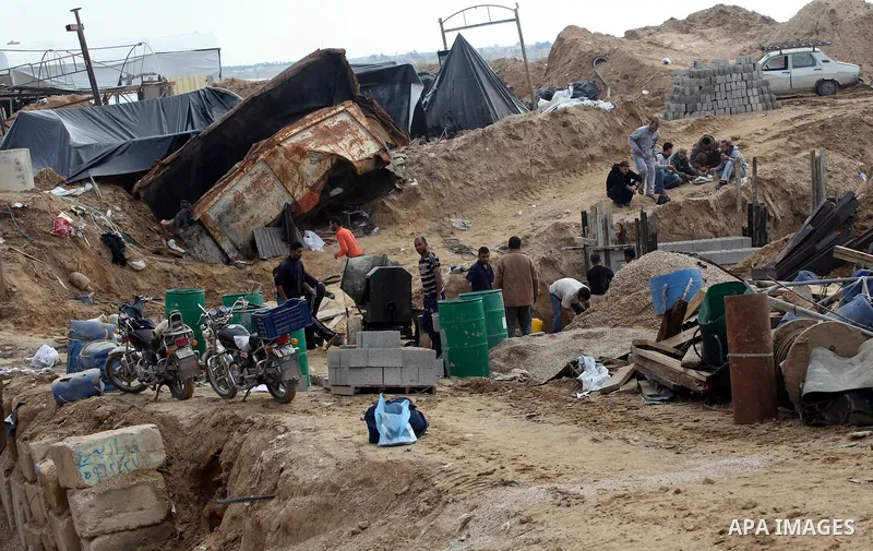 Palestinians work at the entrance of a smuggling tunnels dug beneath the Egyptian-Gaza border in Rafah, in the southern Gaza Strip November 27, 2012. Knee-deep in craters carved out by Israeli air strikes, Palestinians w...