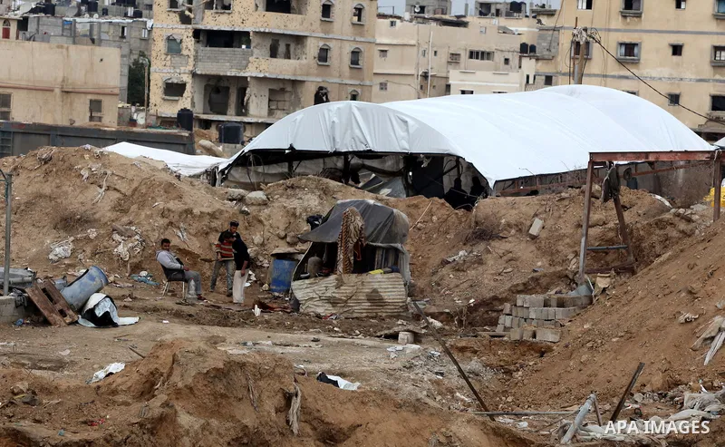 Palestinians work at the entrance of a smuggling tunnels dug beneath the Egyptian-Gaza border in Rafah, in the southern Gaza Strip November 27, 2012. Knee-deep in craters carved out by Israeli air strikes, Palestinians w...