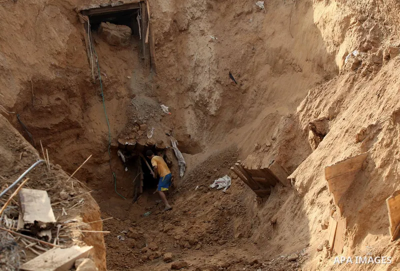 A Palestinian works at the entrance of a smuggling tunnel dug beneath the Egyptian-Gaza border in Rafah, in the southern Gaza Strip November 27, 2012. Knee-deep in craters carved out by Israeli air strikes, Palestinians...