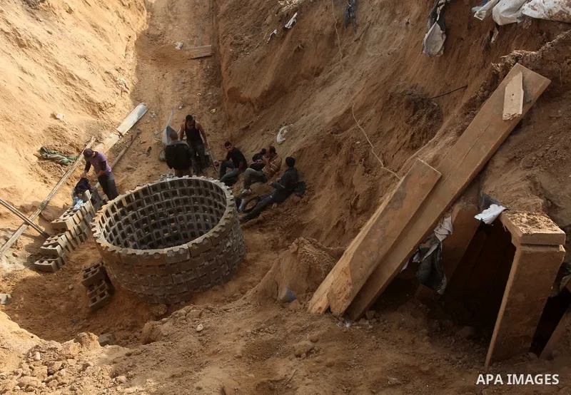 Palestinians work at the entrance of a smuggling tunnels dug beneath the Egyptian-Gaza border in Rafah, in the southern Gaza Strip November 27, 2012. Knee-deep in craters carved out by Israeli air strikes, Palestinians w...