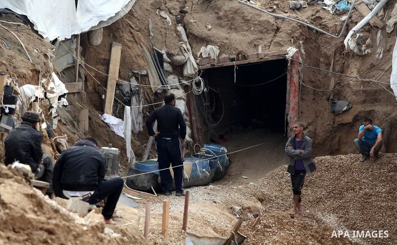 Palestinians work at the entrance of a smuggling tunnels dug beneath the Egyptian-Gaza border in Rafah, in the southern Gaza Strip November 27, 2012. Knee-deep in craters carved out by Israeli air strikes, Palestinians w...