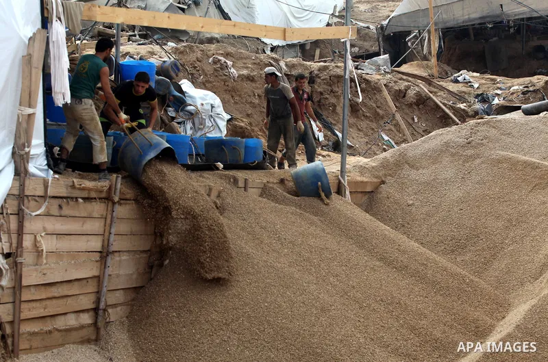 Palestinians work at the entrance of a smuggling tunnels dug beneath the Egyptian-Gaza border in Rafah, in the southern Gaza Strip November 27, 2012. Knee-deep in craters carved out by Israeli air strikes, Palestinians w...