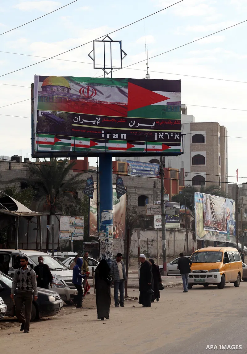 Palestinians walk next to a placard reads in Arabic "Thanks for Iran" in Gaza city on November 27, 2012. The commander of Iran's elite Revolutionary Guards has publicly admitted that his forces supplied the Islamic milit...