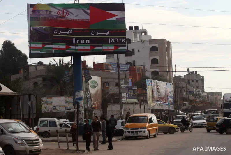 Palestinians walk next to a placard reads in Arabic "Thanks for Iran" in Gaza city on November 27, 2012. The commander of Iran's elite Revolutionary Guards has publicly admitted that his forces supplied the Islamic milit...