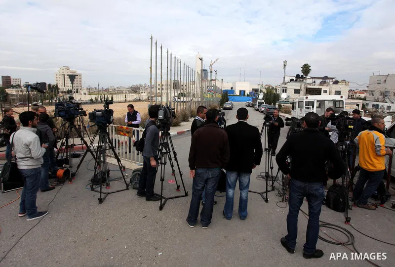 The local and international press gather meters away from the mausoleum of the late Palestinian leader Yasser Arafat, protected by blue tarpaulin on November 27, 2012, at the Muqataa in the West Bank city of Ramallah. Th...