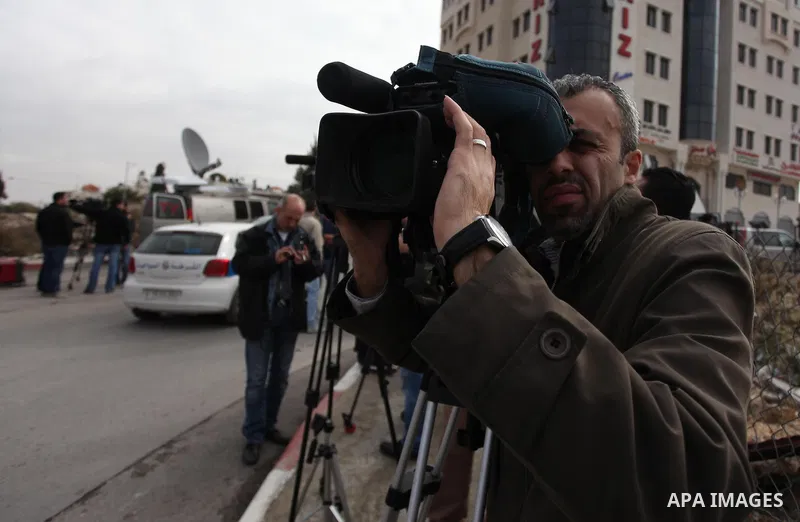 The local and international press gather meters away from the mausoleum of the late Palestinian leader Yasser Arafat, protected by blue tarpaulin on November 27, 2012, at the Muqataa in the West Bank city of Ramallah. Th...