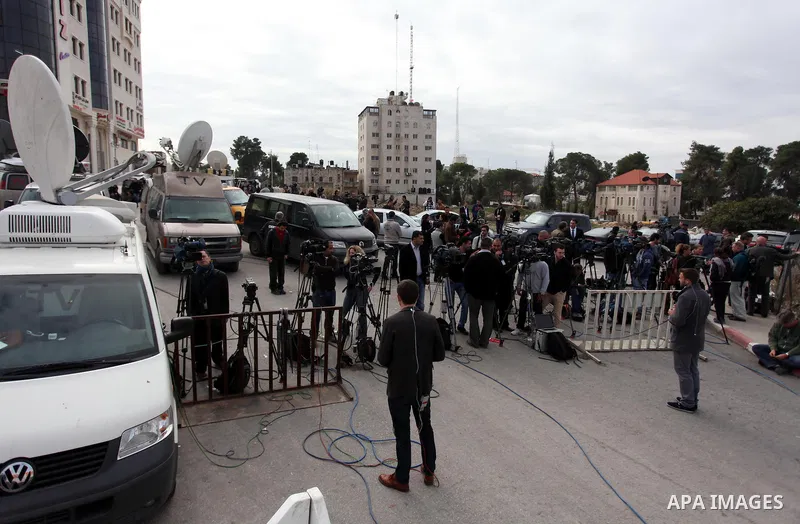 The local and international press gather meters away from the mausoleum of the late Palestinian leader Yasser Arafat, protected by blue tarpaulin on November 27, 2012, at the Muqataa in the West Bank city of Ramallah. Th...