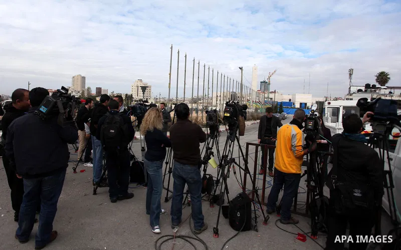 The local and international press gather meters away from the mausoleum of the late Palestinian leader Yasser Arafat, protected by blue tarpaulin on November 27, 2012, at the Muqataa in the West Bank city of Ramallah. Th...