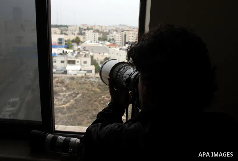 A Palestinian photographer takes photos for the mausoleum of the late Palestinian leader Yasser Arafat, protected by blue tarpaulin on November 27, 2012, at the Muqataa in the West Bank city of Ramallah. The remains of i...