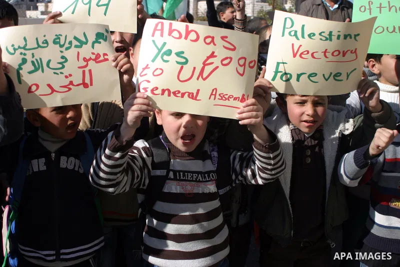 Palestinians student hold posters of Palestinian President Mahmoud Abbas during a rally supporting the Palestinian UN bid for observer state status, in the West Bank city of Hebron, Nov. 28, 2012. The Palestinians will r...