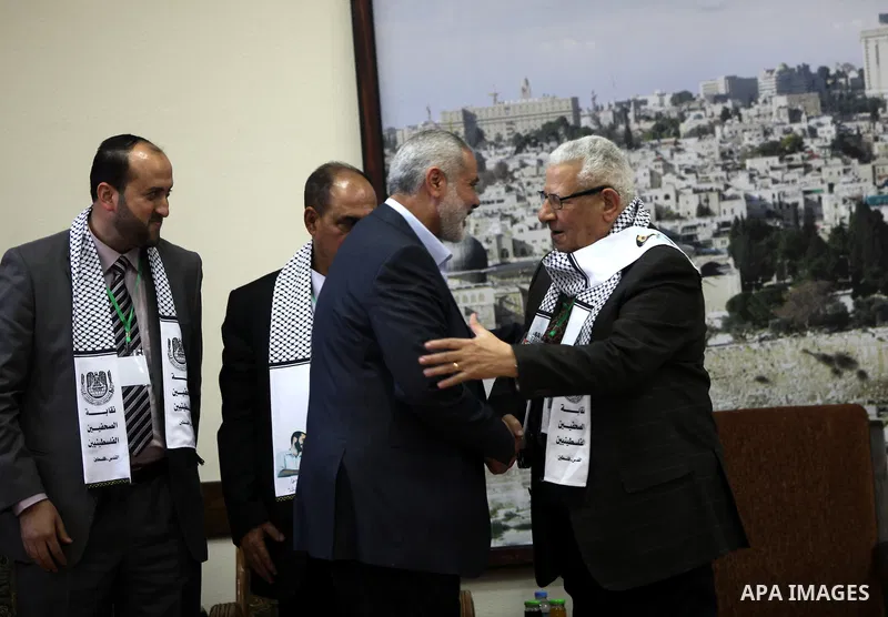 Palestinian Prime Minister in Gaza strip Ismail Haniyeh shakes hands with Makram Ahmed, the Secretary General of the Arab Journalists Union during his visit in Gaza city on November 28, 2012. Israeli aircraft killed 3 an...