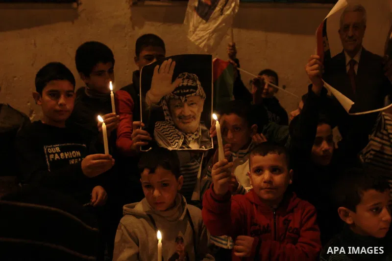 Children hold pictures of President of the Palestine Liberation Organization Mahmoud Abbas and late Palestinian leader Yasser Arafat during a rally at Balata refugee camp near the West Bank city of Nablus, 28 November 20...