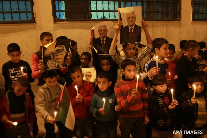 Children hold pictures of President of the Palestine Liberation Organization Mahmoud Abbas and late Palestinian leader Yasser Arafat during a rally at Balata refugee camp near the West Bank city of Nablus, 28 November 20...