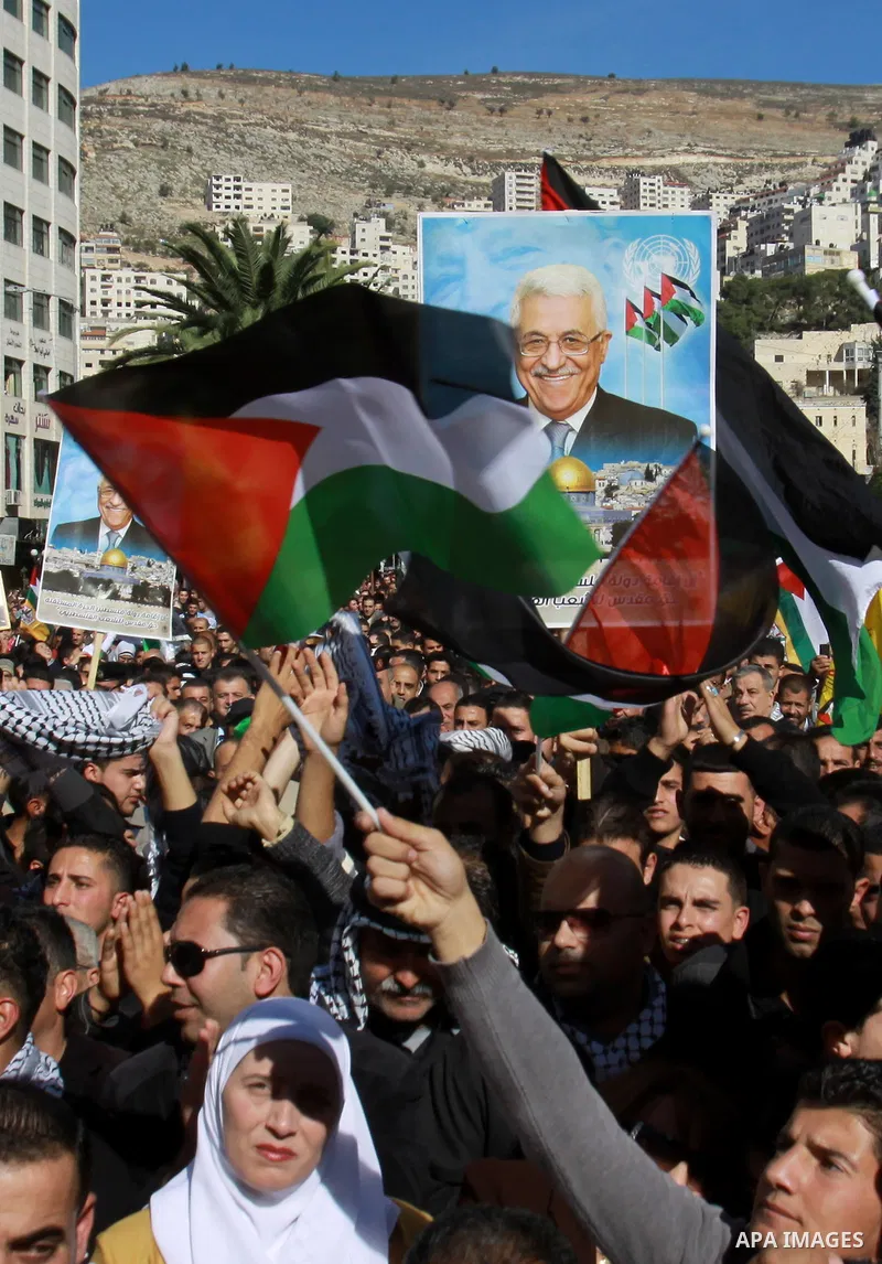 Palestinians hold up portraits of Palestinian President Mahmoud Abbas during a rally supporting the Palestinian UN bid for observer state status, in the West Bank city of Nablus, 29 November 2012. Abbas is to press the U...