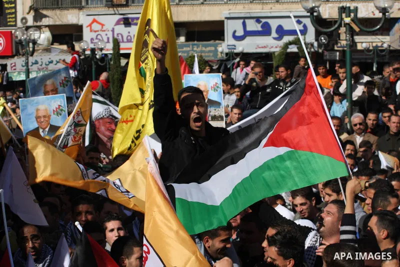 Palestinians hold up portraits of Palestinian President Mahmoud Abbas during a rally supporting the Palestinian UN bid for observer state status, in the West Bank city of Nablus, 29 November 2012. Abbas is to press the U...