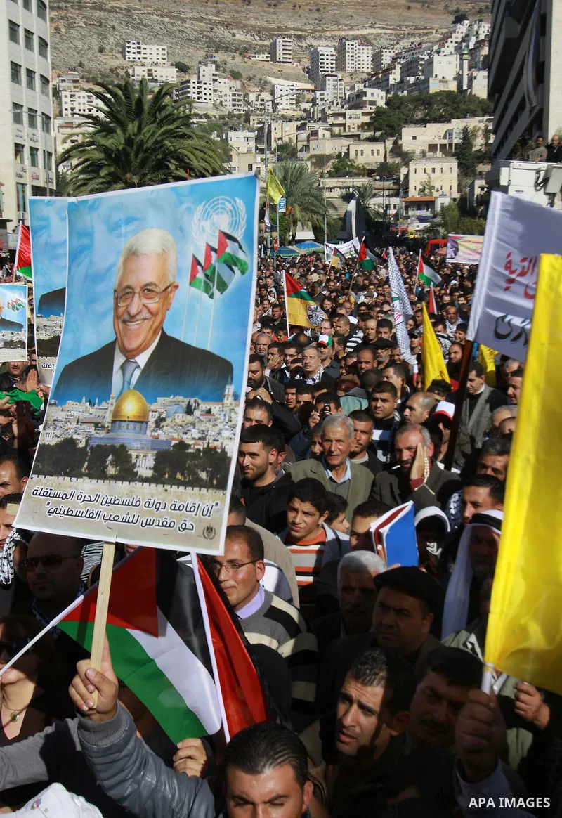 Palestinians hold up portraits of Palestinian President Mahmoud Abbas during a rally supporting the Palestinian UN bid for observer state status, in the West Bank city of Nablus, 29 November 2012. Abbas is to press the U...