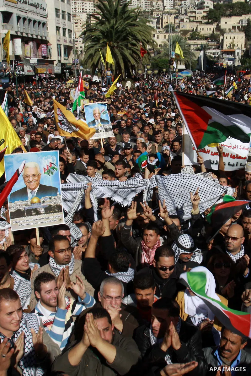 Palestinians hold up portraits of Palestinian President Mahmoud Abbas during a rally supporting the Palestinian UN bid for observer state status, in the West Bank city of Nablus, 29 November 2012. Abbas is to press the U...