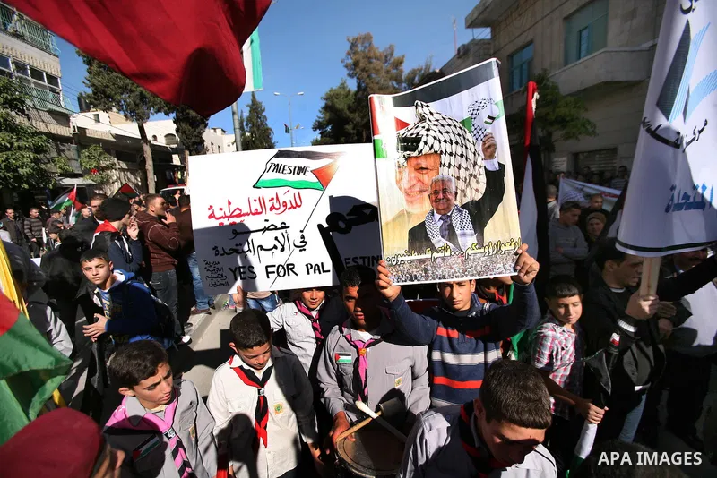 People march with giant Palestinian flags during a rally supporting the Palestinian UN bid for observer state status, in the West Bank city of Hebron, Thursday Nov. 29, 2012. The Palestinians are certain to win U.N. reco...