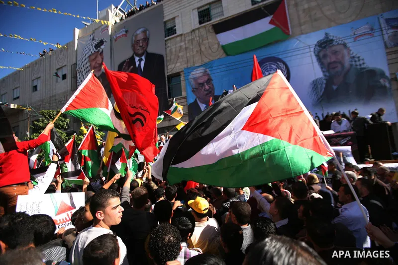People march with giant Palestinian flags during a rally supporting the Palestinian UN bid for observer state status, in the West Bank city of Hebron, Thursday Nov. 29, 2012. The Palestinians are certain to win U.N. reco...