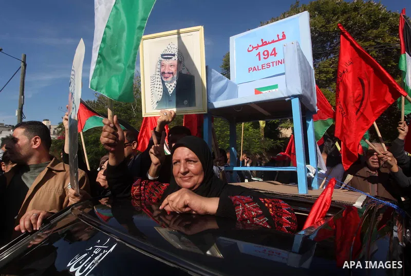 Palestinians take part in a rally in support of the efforts of President Mahmoud Abbas (pictured in poster) to secure a diplomatic upgrade at the United Nations, in Gaza City November 29, 2012. The U.N. General Assembly...
