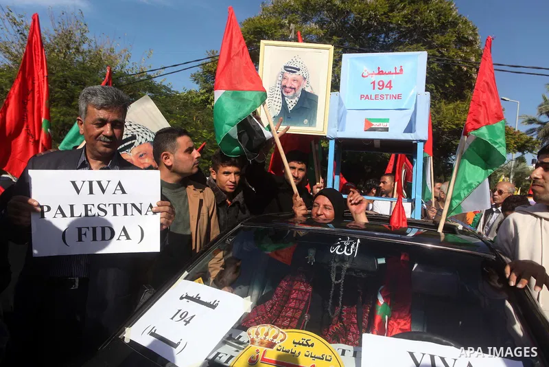 Palestinians take part in a rally in support of the efforts of President Mahmoud Abbas (pictured in poster) to secure a diplomatic upgrade at the United Nations, in Gaza City November 29, 2012. The U.N. General Assembly...