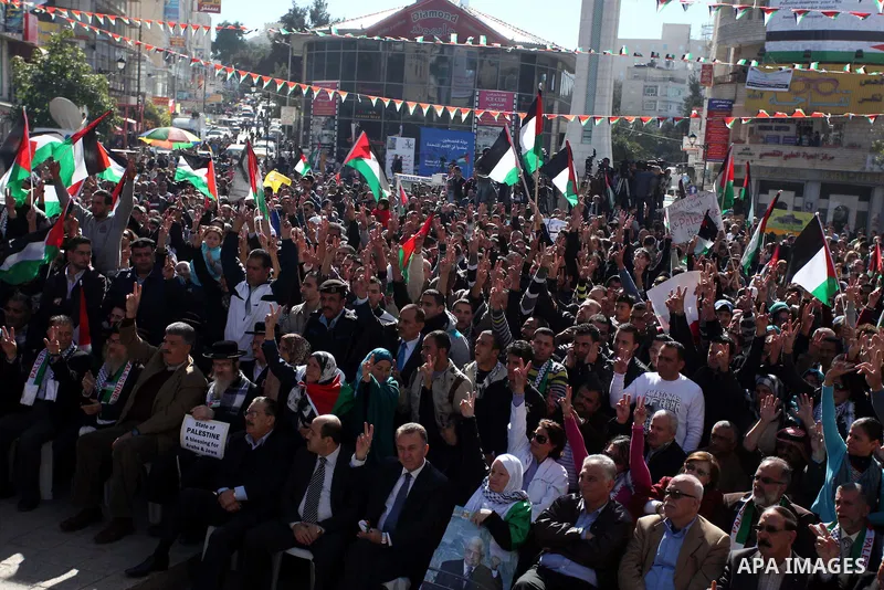 Palestinians wave their national flag during a rally in the West Bank city of Ramallah on November 29, 2012 to support Palestinian leader Mahmud Abbas who is heading to the United Nations General Assembly today with huge...