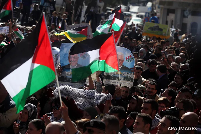 Palestinians wave their national flag during a rally in the West Bank city of Ramallah on November 29, 2012 to support Palestinian leader Mahmud Abbas who is heading to the United Nations General Assembly today with huge...