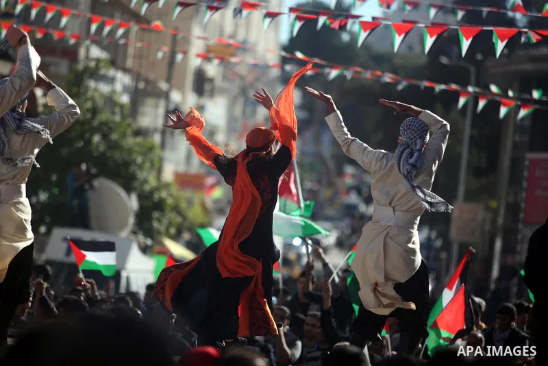Palestinians perform traditional dance during a rally in the West Bank city of Ramallah on November 29, 2012 to support Palestinian leader Mahmud Abbas who is heading to the United Nations General Assembly today with hug...