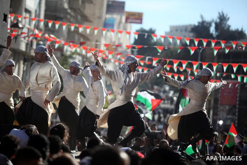 Palestinians perform traditional dance during a rally in the West Bank city of Ramallah on November 29, 2012 to support Palestinian leader Mahmud Abbas who is heading to the United Nations General Assembly today with hug...