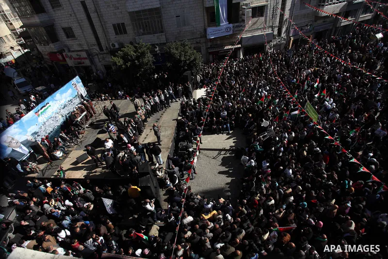 Palestinians wave their national flag during a rally in the West Bank city of Ramallah on November 29, 2012 to support Palestinian leader Mahmud Abbas who is heading to the United Nations General Assembly today with huge...