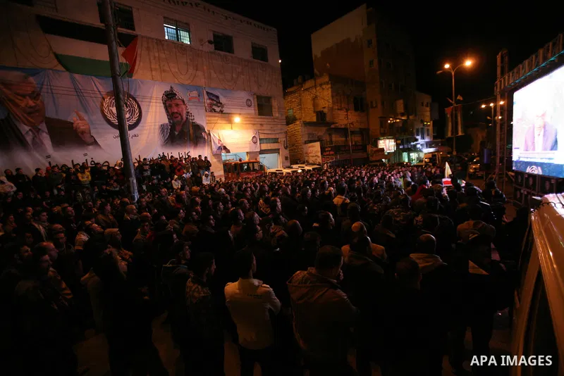 Palestinians wave their national flag during the speech of President Mahmoud Abbas in the U.N. General Assembly, in the West Bank city of Hebron, November 29, 2012. The 193-nation U.N. General Assembly overwhelmingly app...