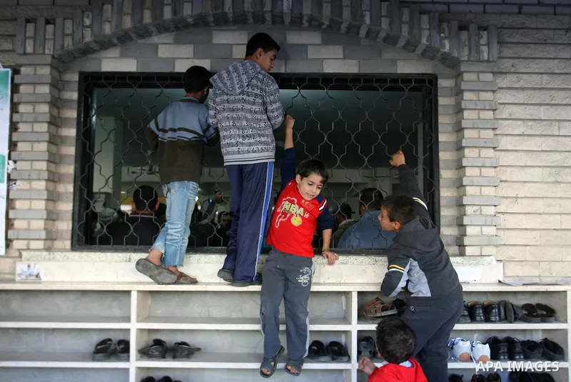 Palestinian boys look at the body of Hussam al-Hams, a member of Hamas' security forces, during his funeral at a mosque in Rafah, in the southern Gaza Strip November 30, 2012. Al-Hams died on Thursday of a wound he suffe...