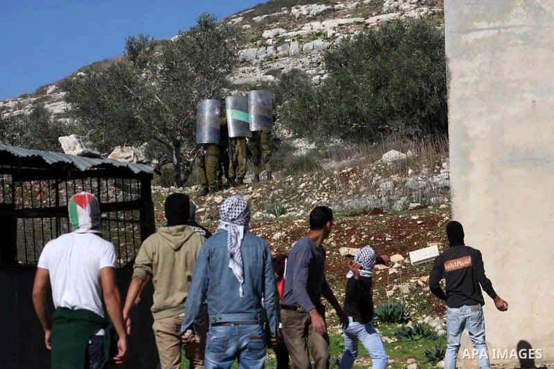 Palestinians throw stones to Israeli soldiers on the sidelines of a demonstration against the expropriations by Israel in the West Bank village of Kafr Qaddum, near Nablus, on November 30, 2012. Photo by Nedal Eshtayah