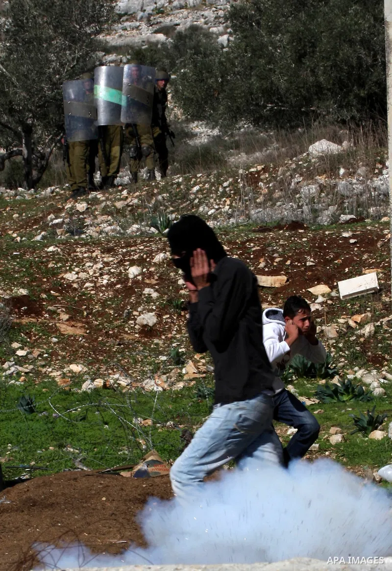 Palestinians throw stones to Israeli soldiers on the sidelines of a demonstration against the expropriations by Israel in the West Bank village of Kafr Qaddum, near Nablus, on November 30, 2012. Photo by Nedal Eshtayah