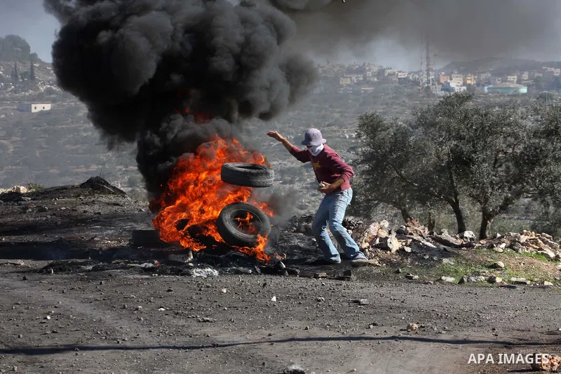 A Palestinian protester burns a tire on the sidelines of a demonstration against the expropriations by Israel in the West Bank village of Kafr Qaddum, near Nablus, on November 30, 2012. Photo by Nedal Eshtayah