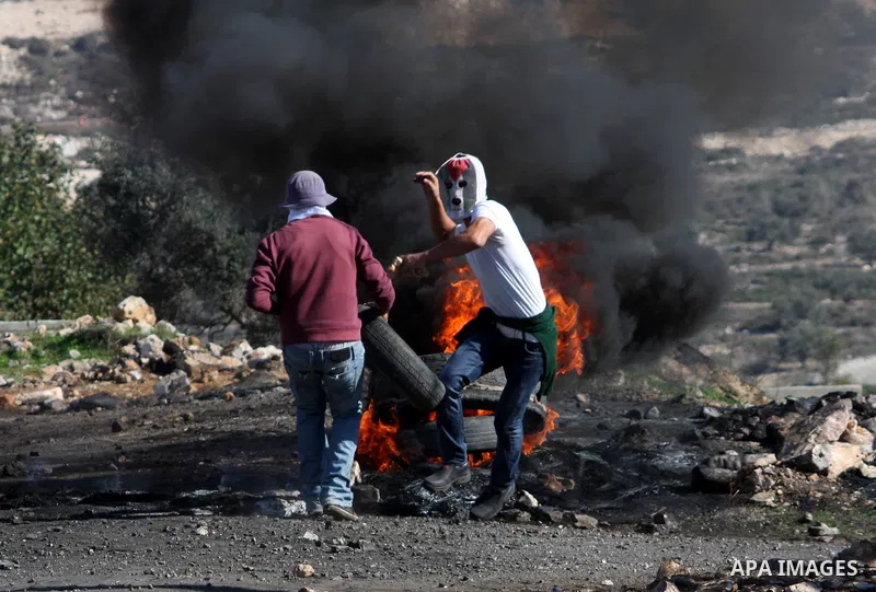Palestinian protesters burn a tire on the sidelines of a demonstration against the expropriations by Israel in the West Bank village of Kafr Qaddum, near Nablus, on November 30, 2012. Photo by Nedal Eshtayah