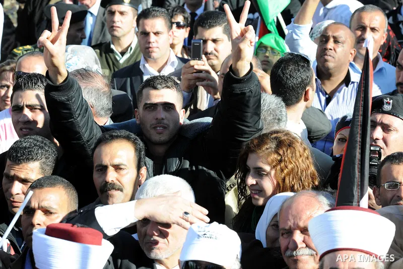 Palestinians wave national flags as they celebrate their successful bid for UN non-member observer state status, in the West Bank city of Ramallah on December 2, 2012, Palestinian President Mahmoud Abbas arrived to the W...