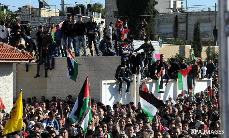 Palestinians wave national flags as they celebrate their successful bid for UN non-member observer state status, in the West Bank city of Ramallah on December 2, 2012, Palestinian President Mahmoud Abbas arrived to the W...