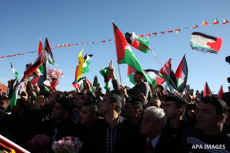 Palestinians wave national flags as they celebrate their successful bid for UN non-member observer state status, in the West Bank city of Ramallah on December 2, 2012, Palestinian President Mahmoud Abbas arrived to the W...