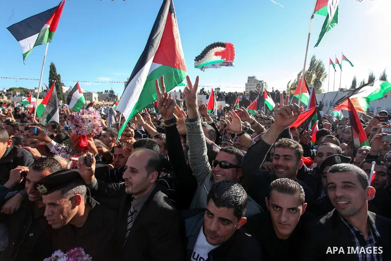 Palestinians wave national flags as they celebrate their successful bid for UN non-member observer state status, in the West Bank city of Ramallah on December 2, 2012, Palestinian President Mahmoud Abbas arrived to the W...