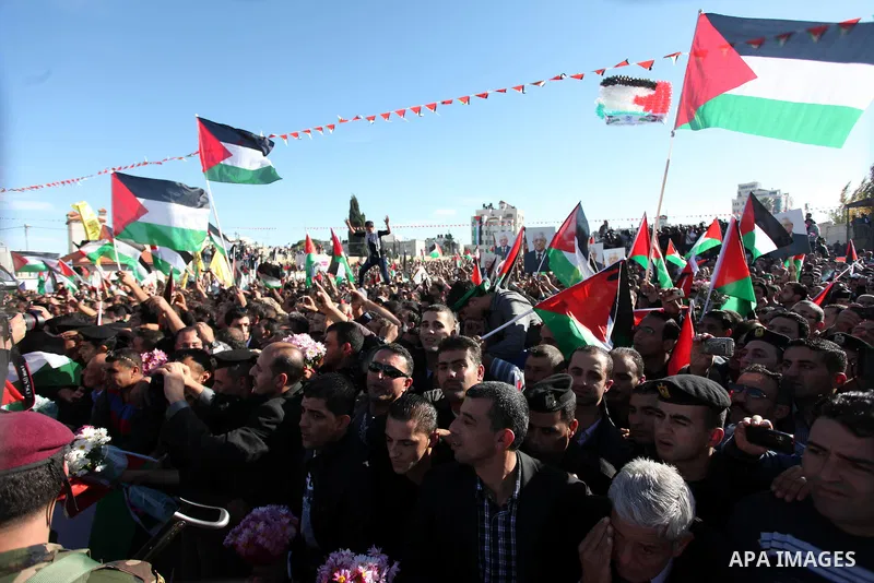 Palestinians wave national flags as they celebrate their successful bid for UN non-member observer state status, in the West Bank city of Ramallah on December 2, 2012, Palestinian President Mahmoud Abbas arrived to the W...