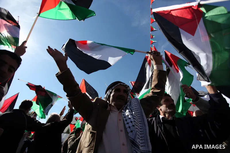 Palestinians wave national flags as they celebrate their successful bid for UN non-member observer state status, in the West Bank city of Ramallah on December 2, 2012, Palestinian President Mahmoud Abbas arrived to the W...