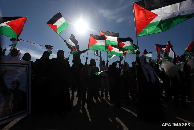 Palestinians wave national flags as they celebrate their successful bid for UN non-member observer state status, in the West Bank city of Ramallah on December 2, 2012, Palestinian President Mahmoud Abbas arrived to the W...