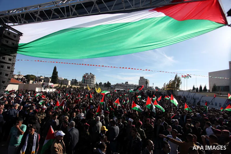 Palestinians wave national flags as they celebrate their successful bid for UN non-member observer state status, in the West Bank city of Ramallah on December 2, 2012, Palestinian President Mahmoud Abbas arrived to the W...