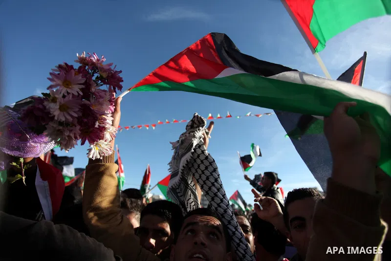 Palestinians wave national flags as they celebrate their successful bid for UN non-member observer state status, in the West Bank city of Ramallah on December 2, 2012, Palestinian President Mahmoud Abbas arrived to the W...
