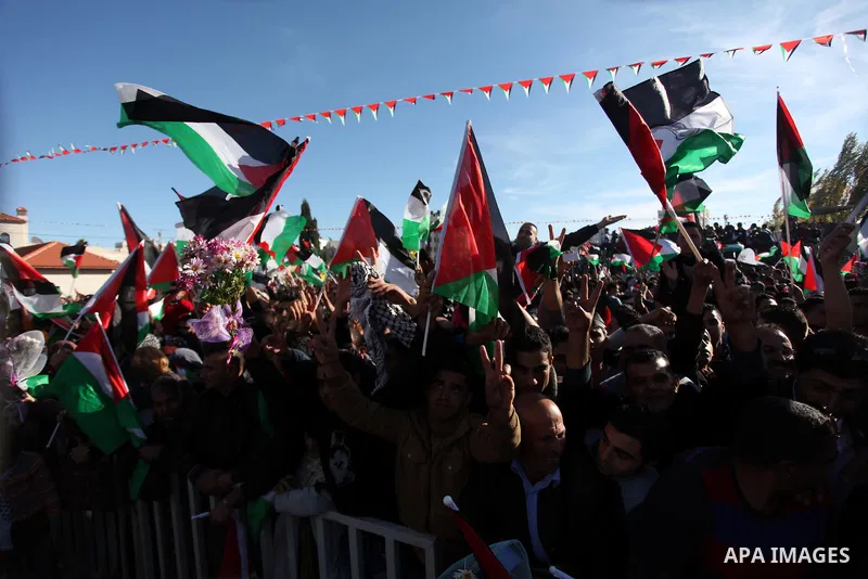 Palestinians wave national flags as they celebrate their successful bid for UN non-member observer state status, in the West Bank city of Ramallah on December 2, 2012, Palestinian President Mahmoud Abbas arrived to the W...